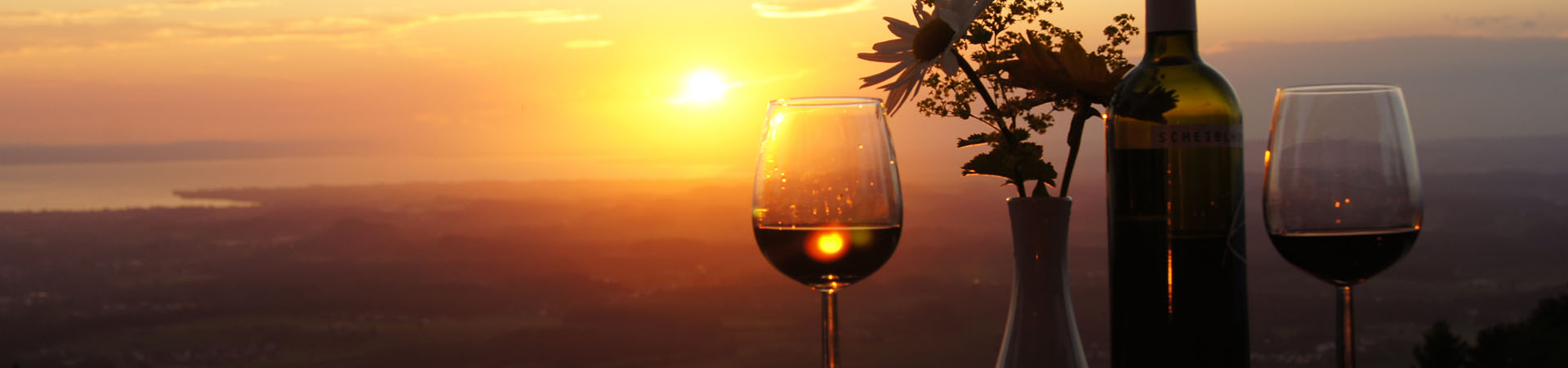 Ein tröpfchen Wein bei Sonnenuntergang mit Blick auf den Bodensee